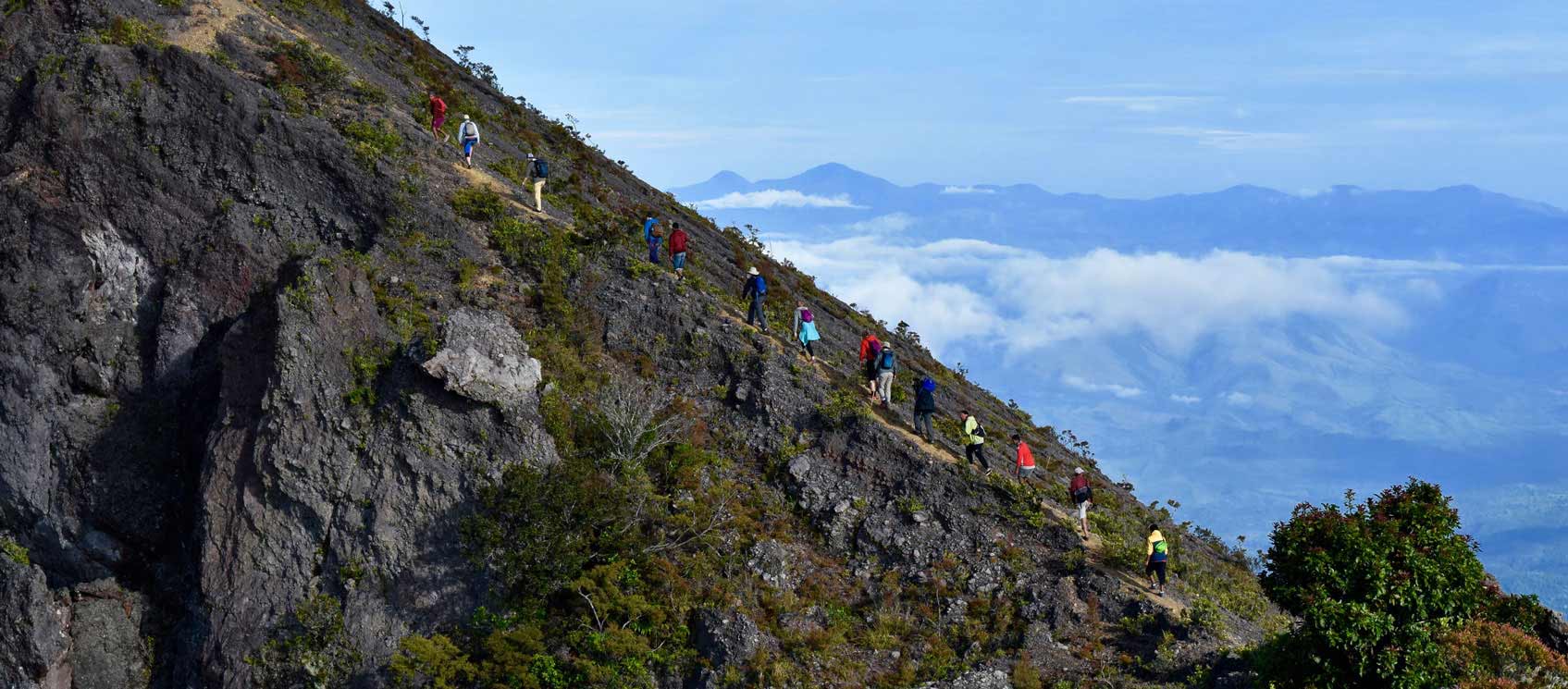 aerial view of fourteen people hiking up a mountain