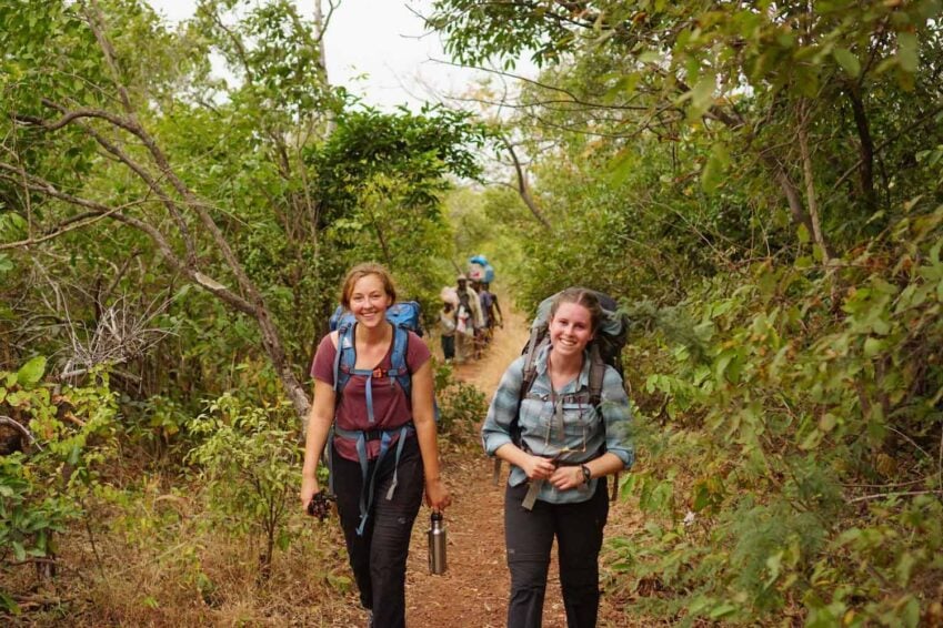 Two women smiling for camera while walking on a trail in Peru